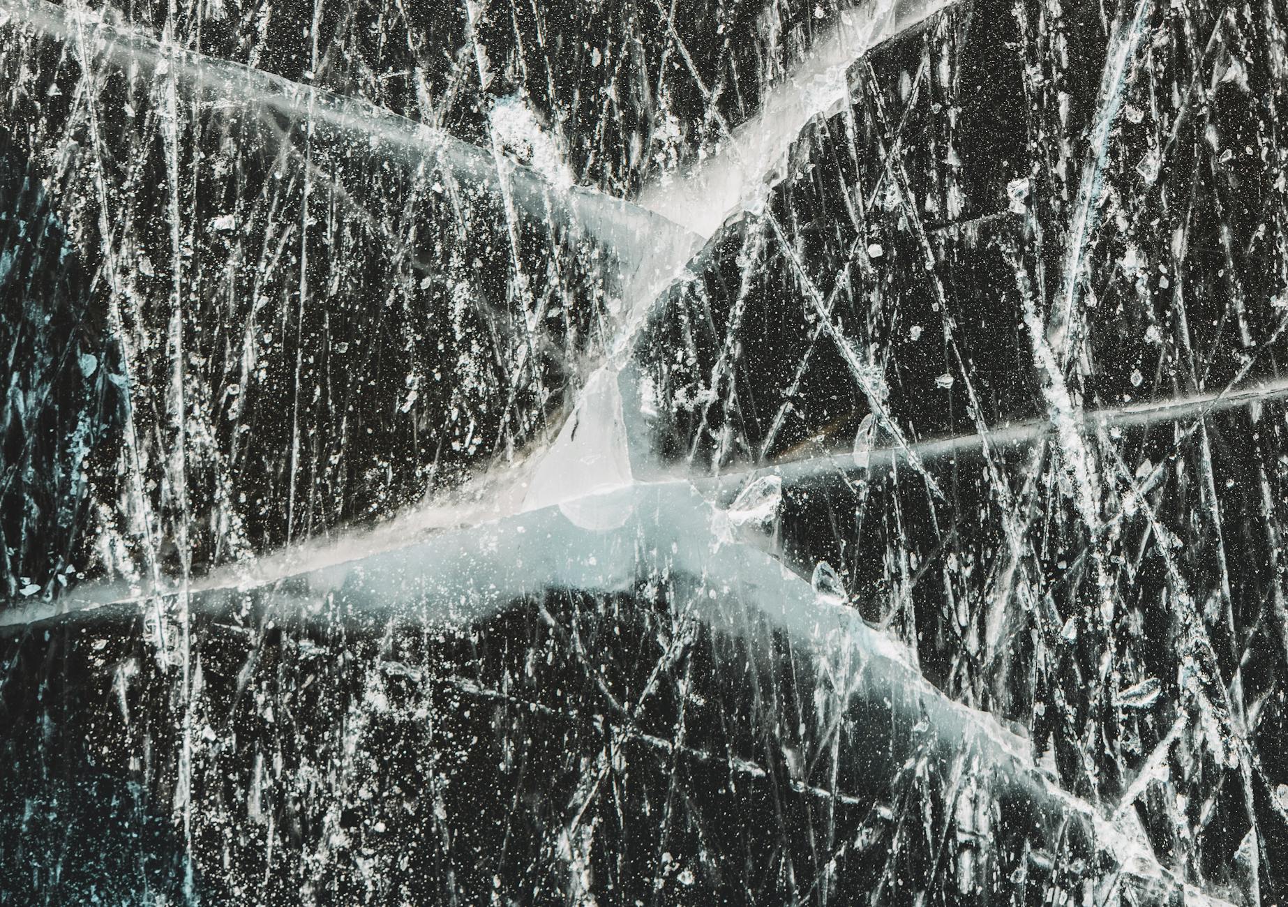 Zbliżenie popękanej powierzchni przypominającej zarysowany poliwęglan