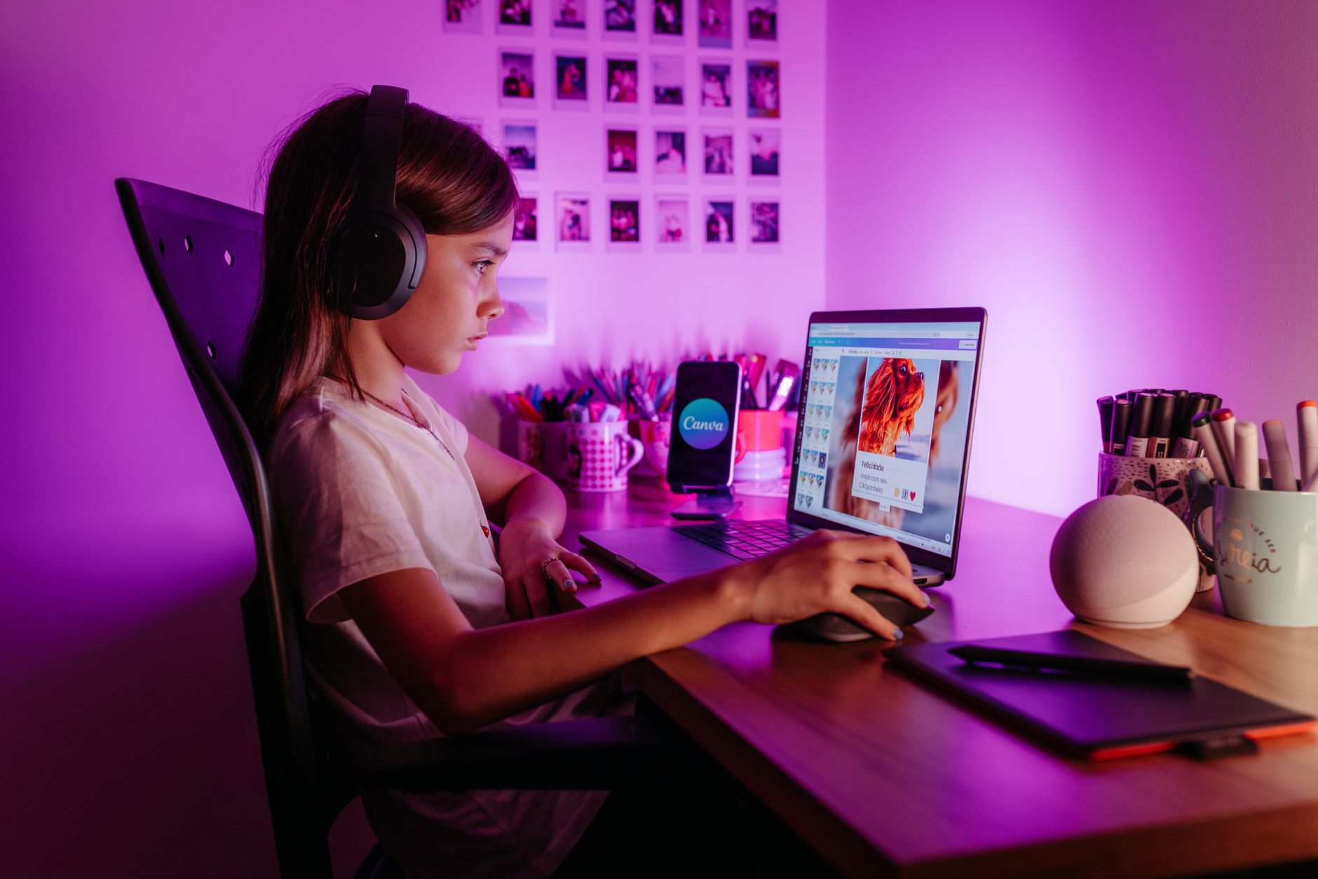 Dziecko w słuchawkach uczy się online przy laptopie w fioletowym świetle