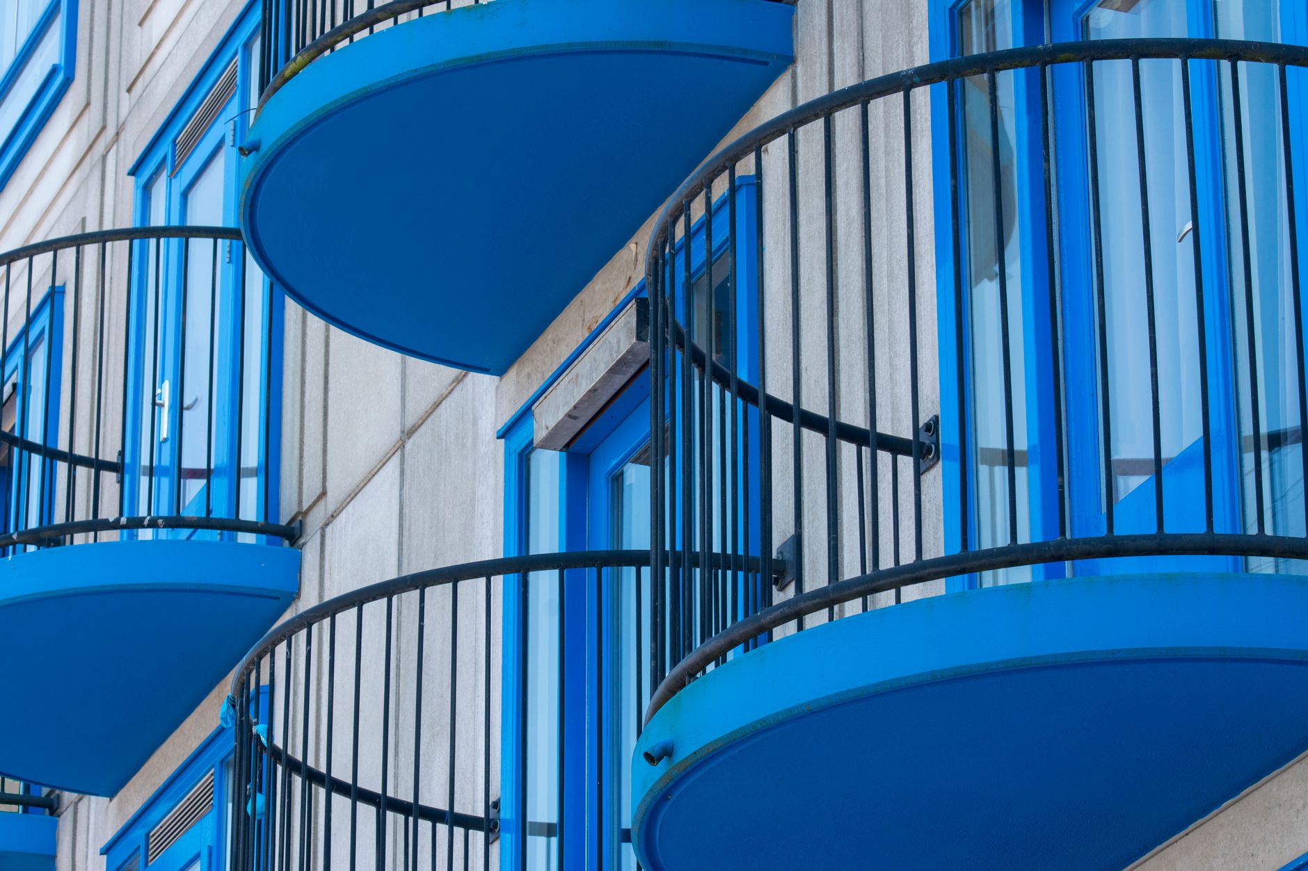 Zbliżenie nowoczesnego budynku z niebieskimi balustradami balkonów