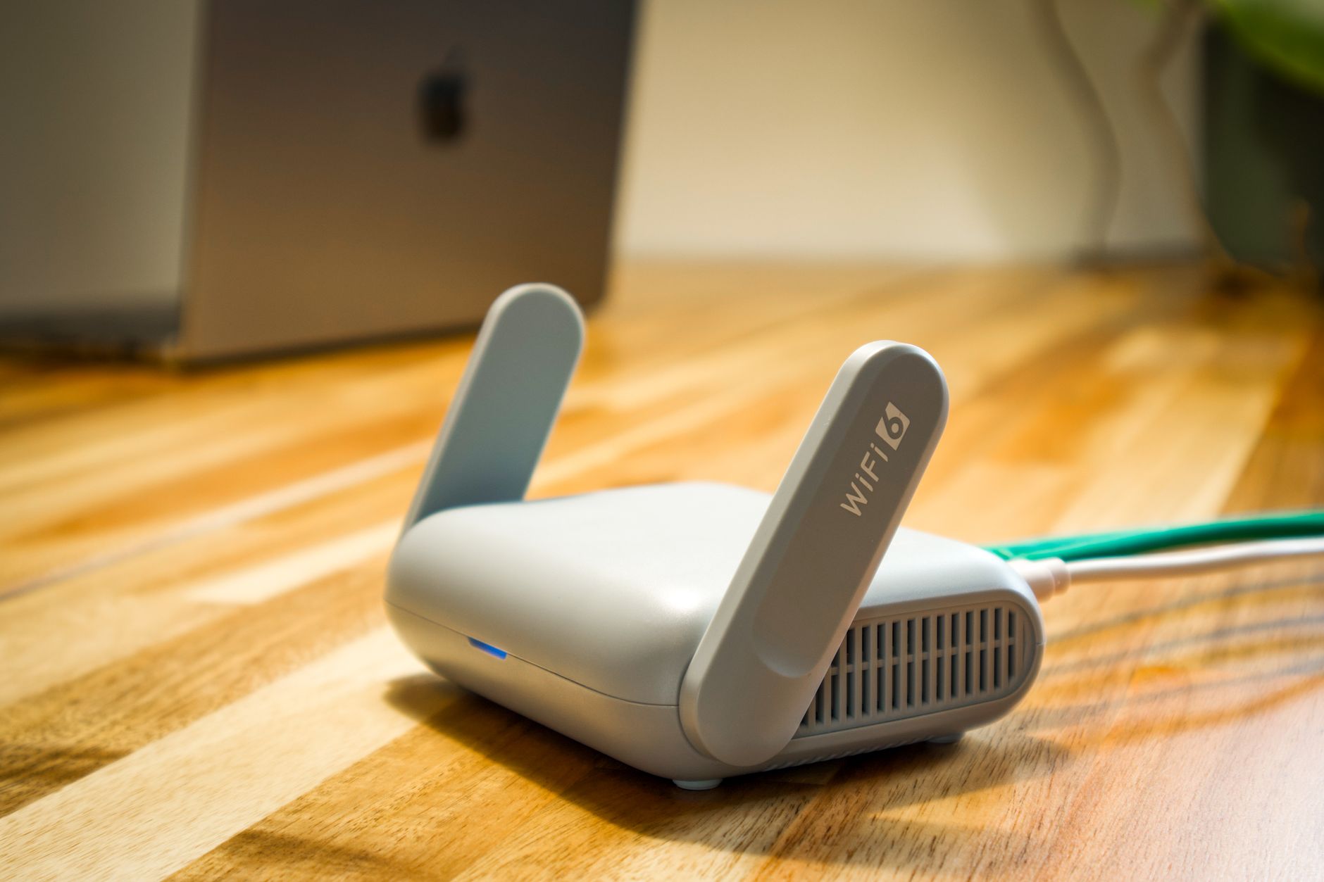 Router Wi‑Fi 6 z antenami na drewnianym biurku